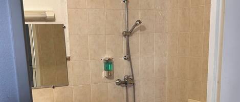 A bathroom with a shower, a sink, and a toilet.