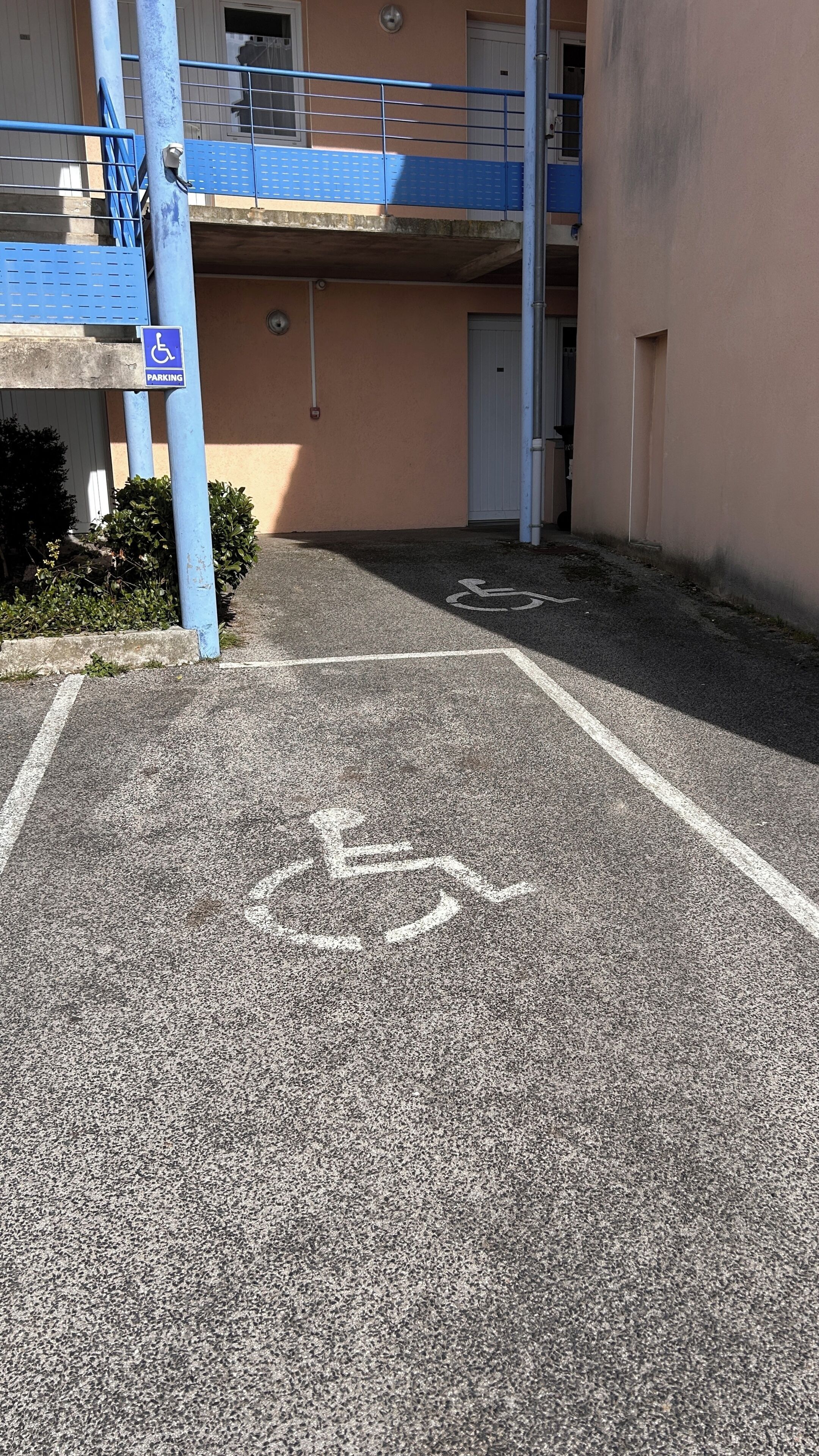 Ein Parkplatz mit einem ausgewiesenen barrierefreien Stellplatz.