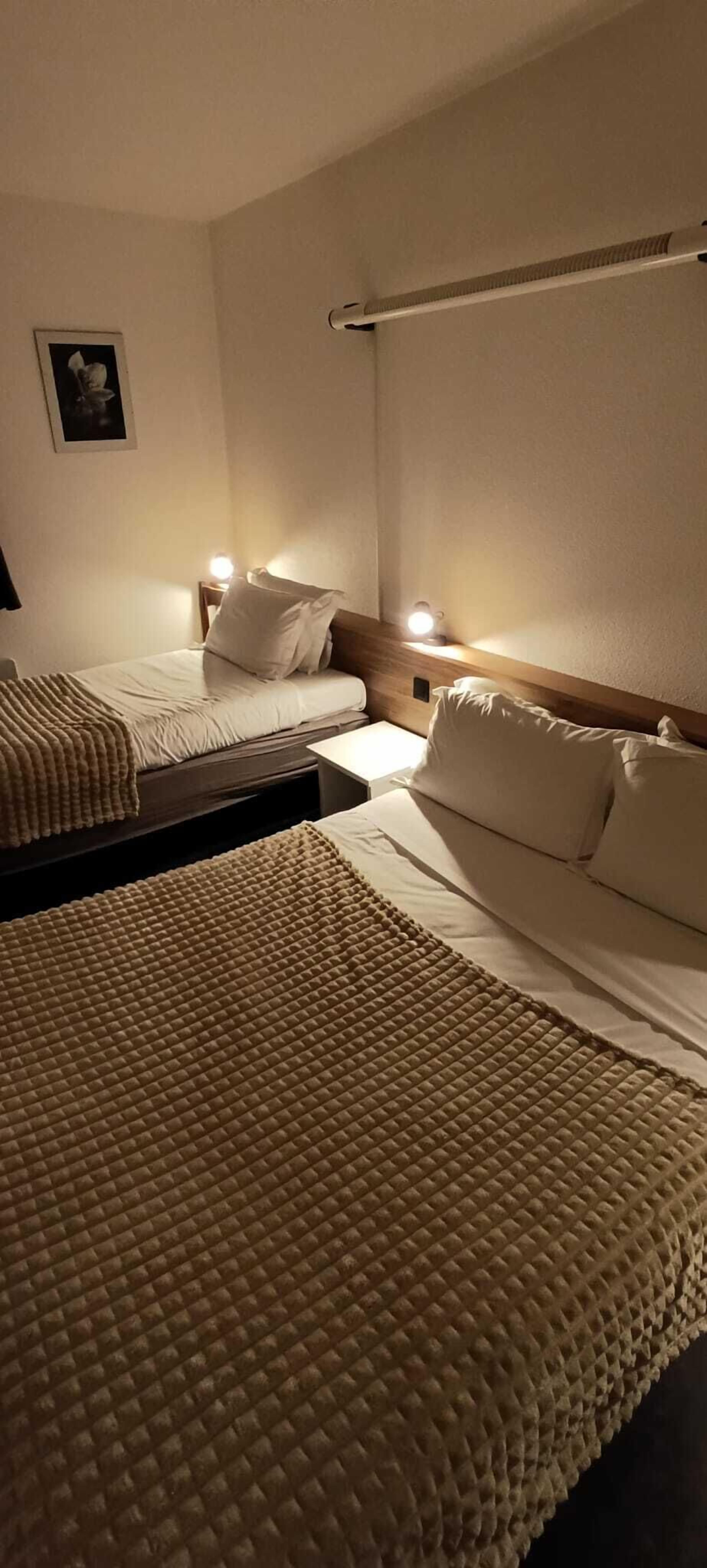 Une chambre d’hôtel avec deux lits, chacun doté d’une tête de lit et de lampes de chevet.