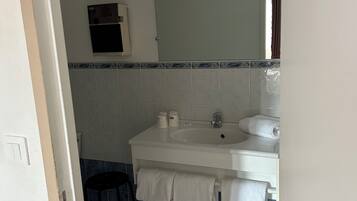 Deluxe vierpersoonskamer | Badkamer | Een douche, handdoeken, zeep, shampoo