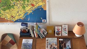 A wooden desk with a map, books, and a lamp.