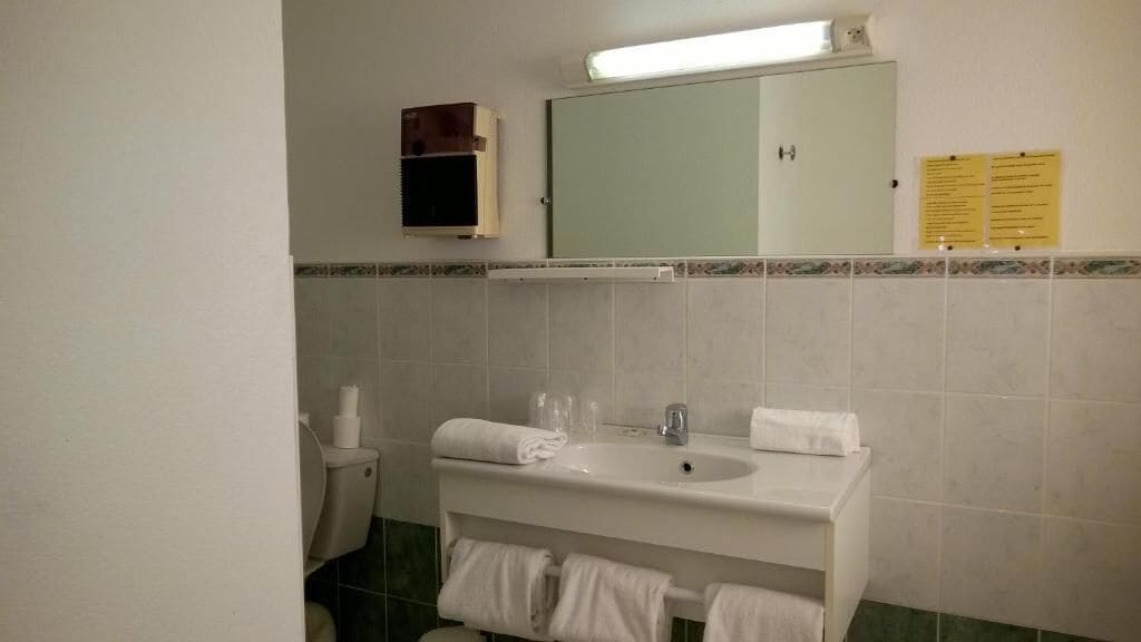 Deluxe vierpersoonskamer | Badkamer | Een douche, een regendouche, een haardroger, handdoeken