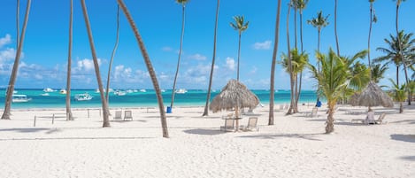 Ranta lähistöllä, aurinkotuoleja, rantapyyhkeitä