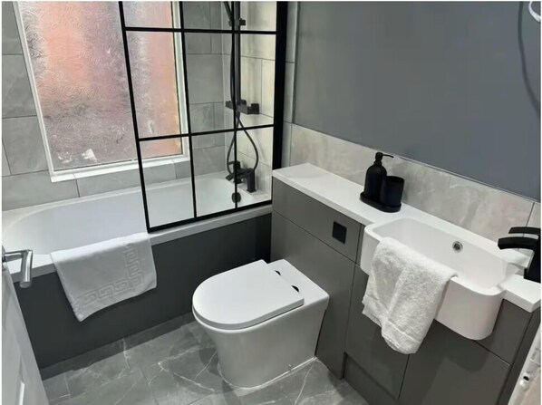 Une salle de bain moderne avec une baignoire, des toilettes et un lavabo.