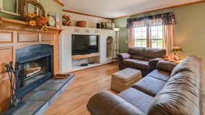 A living room with a fireplace, television, and comfortable seating. - 100-Acre Garden of the Gods Retreat w/ Hot Tub (Elizabethtown)