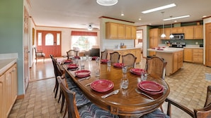 A spacious dining area with a large wooden table set for six, surrounded by wooden chairs. - 100-Acre Garden of the Gods Retreat w/ Hot Tub (Elizabethtown)