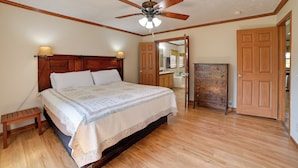 A bedroom with a wooden bed, a ceiling fan, a nightstand, and a wooden wardrobe. - 100-Acre Garden of the Gods Retreat w/ Hot Tub (Elizabethtown)