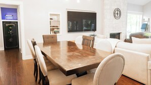 Ein Essbereich mit Holztisch und Stühlen, einem weißen Sofa und einem Kamin.