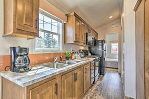 A kitchen with wooden cabinets, a built-in microwave, and a coffee maker.