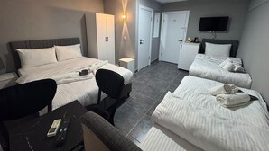 A hotel room with two beds, a desk, a chair, a TV, a wardrobe, and a small kitchenette. - Old City Kadıköy Otel (Istanbul)
