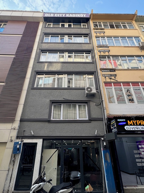 Un edificio de varios pisos con un letrero que dice 'OLD CITY KADIKOY'.