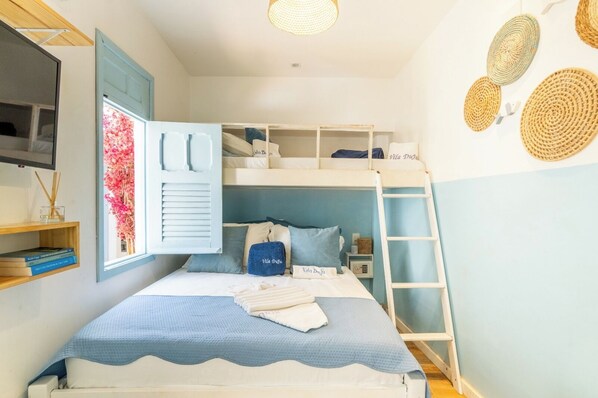 A bunk bed room with a TV, a window with shutters, and a bedside table. - Pousada Vila Duju (Ipojuca)