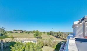 A residential property with a view of the sea, a garden, and a clear sky. - Casa da Cestaria T2 Duplex by YHA (Cabanas de Tavira)