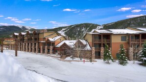 A lodge with multiple wooden buildings, a snow-covered landscape, and a clear sky. - Luxury Renovated 2BR | Walk to Slopes I River View (Keystone)