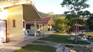 A building with a tiled roof, a paved driveway, and a small pond. - Rancho Pica Pau (Ubatuba)