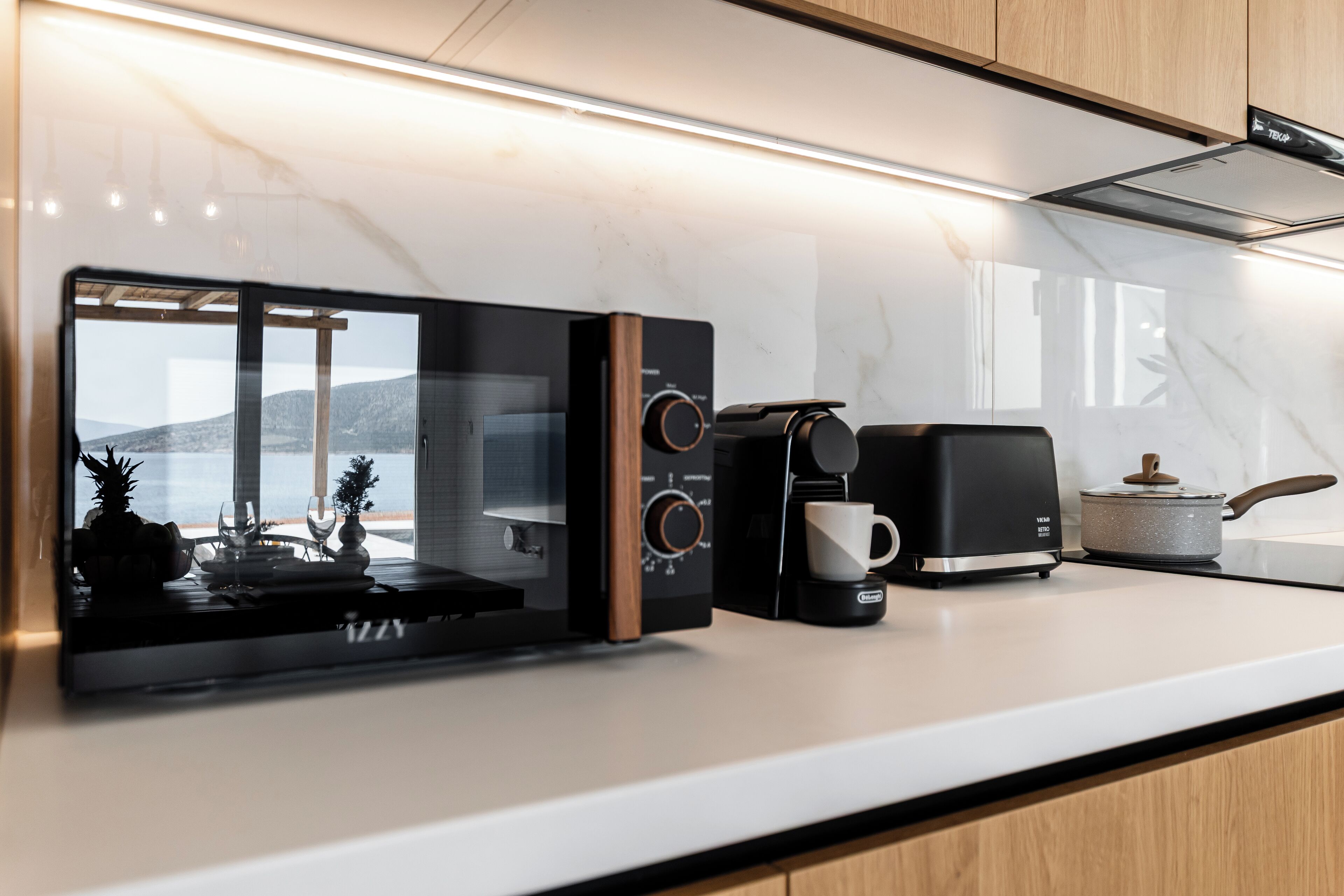 A modern kitchen with a built-in microwave, coffee maker, and toaster.