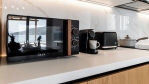 Una cucina moderna dotata di forno a microonde, macchina del caffè e tostapane.