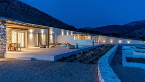 Una casa moderna con piscina, area salotto esterna e facciata in pietra.