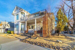 A two-story house with a balcony, a front porch, and a brick column.