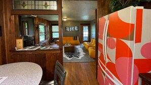 A cabin interior with a dining area, kitchen, and living space.