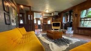 A cozy living room with a yellow sofa set, a central coffee table, and a large rug.