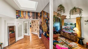 A spacious living area with a wooden floor, a sofa, a coffee table, and a TV.