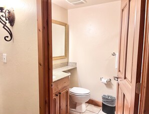 Un baño pequeño con inodoro, lavabo y espejo.