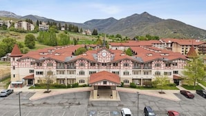 A large building with a central entrance, multiple balconies, and a parking lot in front. - 3074 | Premium Escape | 2Q Suite Near Park City (Midway)