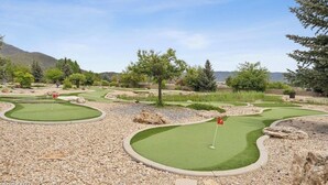 A miniature golf course with multiple holes, surrounded by trees and a mountainous backdrop. - 1057 | King Villa w/ Kitchen Near Soldier Hollow (Midway)