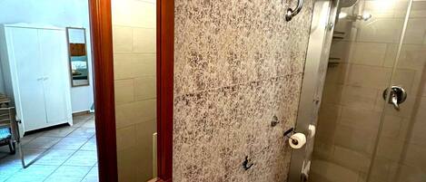 Een badkamer met twee wasbakken, een toilet en een douche.