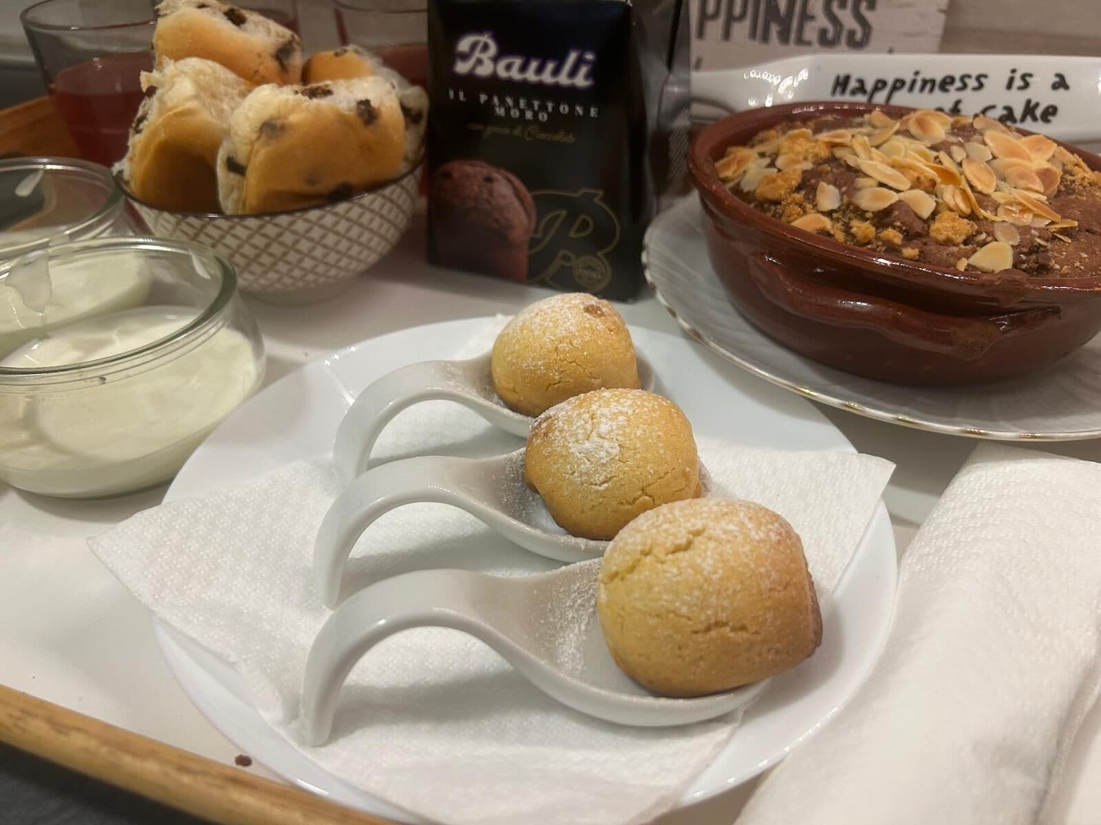 A tray with pastries, a bowl of dessert, and a sign saying "Happiness is a state of cake".