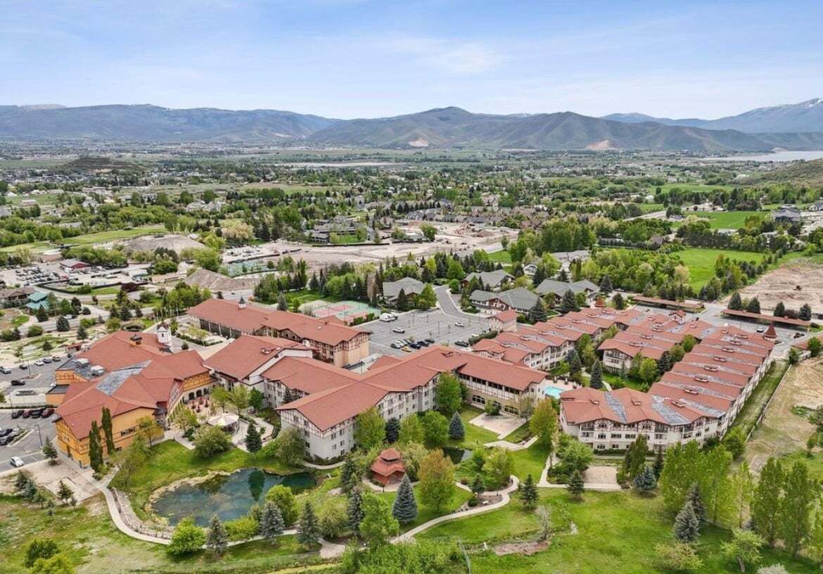 A large hotel complex with multiple buildings, a central courtyard, and a swimming pool.