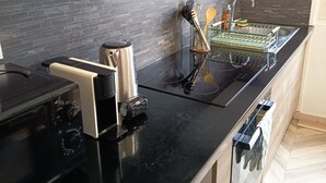 Una cocina moderna con encimera negra, electrodomésticos de acero inoxidable y armarios de madera.