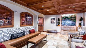 A cozy lobby with a wooden ceiling, a bench, a sofa, and a fireplace. - 206 | Midway Stay | 2Q Suite Near Park City + Pool (Midway)