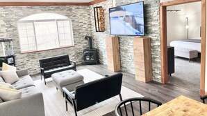 Een gezellige woonkamer met een stenen muur, een open haard, een televisie en een comfortabele zithoek.