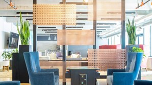 A modern office space with two blue chairs, a glass table, and a partition with a woven design. - East Side Studio Apt - Near Brady St and Fiserv with Balcony (Milwaukee)