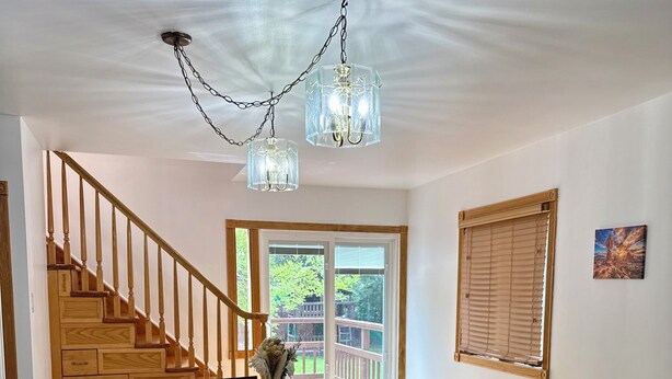 A dining area with a wooden staircase, a chandelier, and a view of the outdoors. - Brilliant bungalow in Midvale ski/hike, fishing, recreational activities (Midvale)