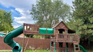A wooden play structure with a slide and a small house. - Brilliant bungalow in Midvale ski/hike, fishing, recreational activities (Midvale)