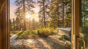 Un patio de piedra con vistas a un bosque y una banca.