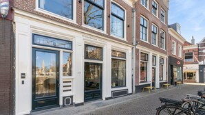 A row of stonebridge apartments with large windows, a bike rack, and a cobblestone street.