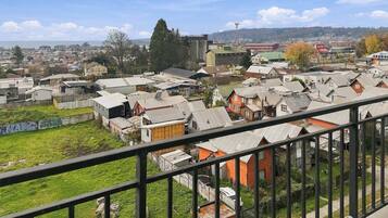 Una zona residencial con casas, un campo cubierto de césped y una vista distante de un pueblo.