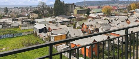 Una zona residencial con casas, un campo cubierto de césped y una vista distante de un pueblo.