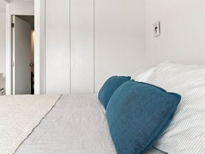 A bedroom with a bed, a white door, and a white wall. - Oceana Suites Alto Panorámico (Villarrica)