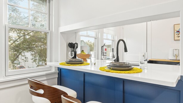 A modern kitchen with a white countertop, blue cabinets, and a large window. - The Bar Loft - Second Floor Suite. Close proximity to NYC and MetLife Stadium. (Bergenfield)