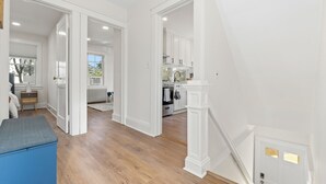 A spacious room with hardwood flooring, white walls, and a blue bench. - The Bar Loft - Second Floor Suite. Close proximity to NYC and MetLife Stadium. (Bergenfield)