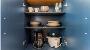 A kitchen with a coffee maker, a slow cooker, and shelves with dishes and glasses. - The Bar Loft - Second Floor Suite. Close proximity to NYC and MetLife Stadium. (Bergenfield)