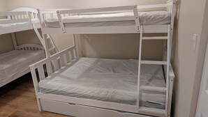 A bunk bed with two levels, each with a mattress and a wooden frame. - South Shore Cottage With Lake View (Pelee)
