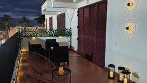 A rooftop terrace with outdoor seating, a pool, and a view of the cityscape.