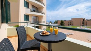 A balcony with a table, chairs, and breakfast items including croissants and orange juice. - Sarah's Apartment by GALMI (Santa Cruz)