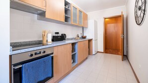 Una cocina moderna con armarios de madera, un horno de acero inoxidable y un reloj en la pared.